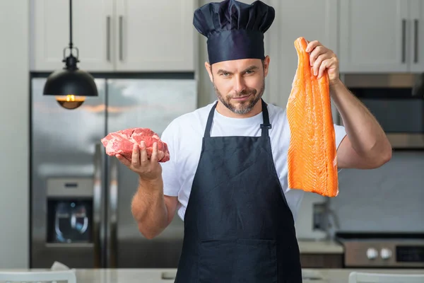 健康自然タンパク質 キッチンで魚や肉 サーモンや牛肉を調理するハンサムな男 健康食品の概念 健康的な食事 タンパク質 生の魚と肉 — ストック写真