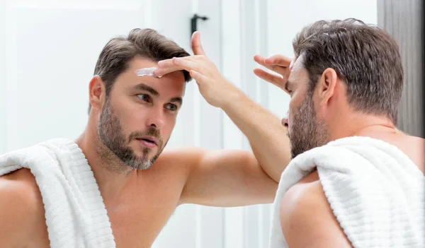 閉じて 男性のしわ 肌のしわに触れるブルネットの男の肖像画 鏡の前にタッチしわを持つ中年の男 老化した皮膚 40代男性化粧品皮膚治療 しわのある男性の顔 — ストック写真
