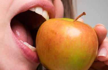 Elmalı sağlıklı beslenme ve sağlıklı dişler yiyen bir kadın. Elma ısırmak. Ağzını kapat.
