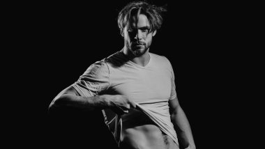 Karanlık arka planda seksi, genç, çıplak bir adam. Baştan çıkarıcı gay