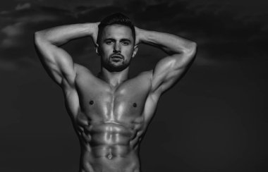 Kaslı vücudu ve çıplak gövdesi olan seksi bir adam. Kaslı, üstsüz, çekici bir adam. Atletik adam, fitness modeli