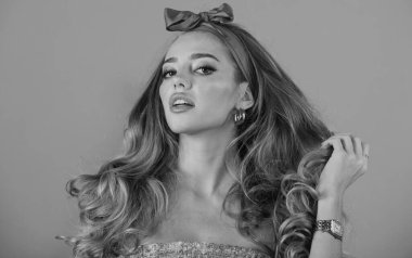 Pembe arka planda izole edilmiş güzel bir genç kadının portresi. Saçları fiyonklu, şehvetli, güzel bir kadın model. Güzel kadın, moda ve güzellik