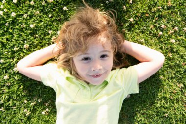 Çocuklar yazın tadını çıkarıyor. Yazın doğa parkında çim portresi üzerinde yatan çocuklar. Şaşırdım. Çocukları heyecanlandırdım.