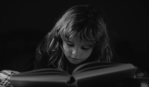 ベッドの上に横になって本を読んでいる可愛い男の子 読書の概念 — ストック写真