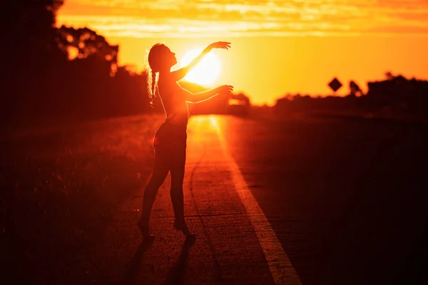 年轻女子在夏日落日的天空中跳舞 人民自由的风格 — 图库照片