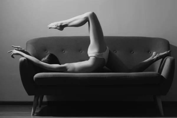 灵活性感的女人在家锻炼 女人在家里沙发上做伸展运动 — 图库照片