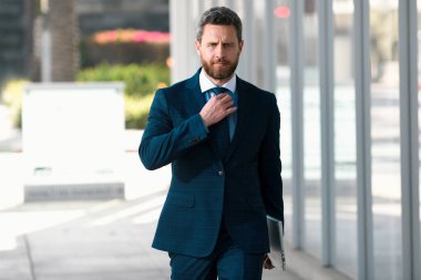 Ofisin dışında duran kendinden emin bir iş adamının portresi.