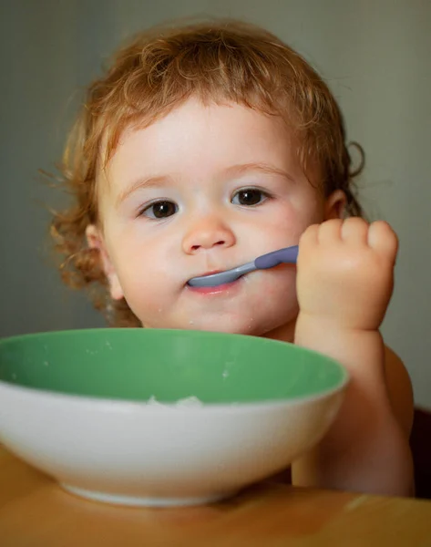 スプーンでかわいい白人の子供の肖像画 空腹乱雑な赤ちゃんとプレートを食べた後ピューレ — ストック写真