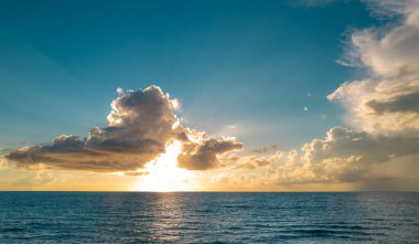 Tropikal sahilde gün doğumu denizi. Güzel bir sahil manzarası. Denizde güzel bir gün batımı. Gökyüzünde gün batımı ve renkli bulutlar. Denizin üzerindeki bulutlar, güneşin doğuşu. Okyanus dalgası