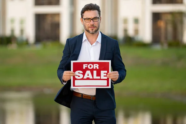 House seller, real estate agents hold sign for sale. Housing estates in the project, buying and selling housing estates. Real estate trading ideas and bank loans for buying and selling houses and land