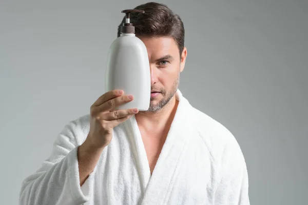 Cosmetic products. Beauty man presentation cosmetic bottle, bottle with dispenser pump for liquid soap, gel or foam. Natural cosmetics cream, spa beauty products. Man advertising cosmetic