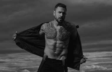 Kendine güvenen, çekici, seksi adam. Deri ceketli, modacı erkek model.
