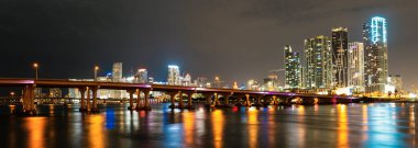 Miami Florida, günbatımı manzarası renkli iş yerleri, konut binaları ve Biscayne Körfezi 'nde köprü. Miami şehir merkezi