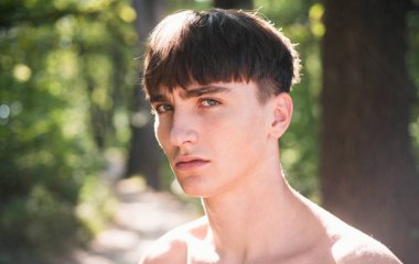 Genç seksi adamın kameraya bakışının stüdyo çekimi. Kendine güveni olan yakışıklı bir adam. Erkek güzellik konsepti