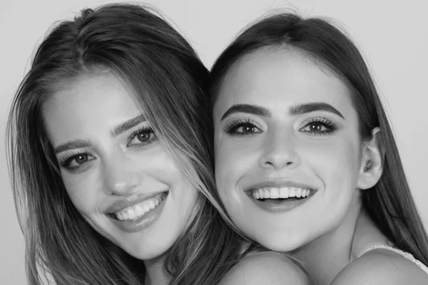 Zwei Lächelnde Attraktive Freundinnen Blond Und Brünett Auf Weißem Hintergrund — Stockfoto