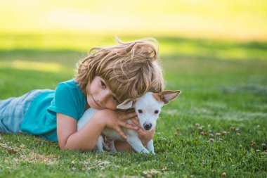 Köpek arkadaşlarınıza sarılın. Yavru köpekli çocuk öpüşüyor ve sarılıyor