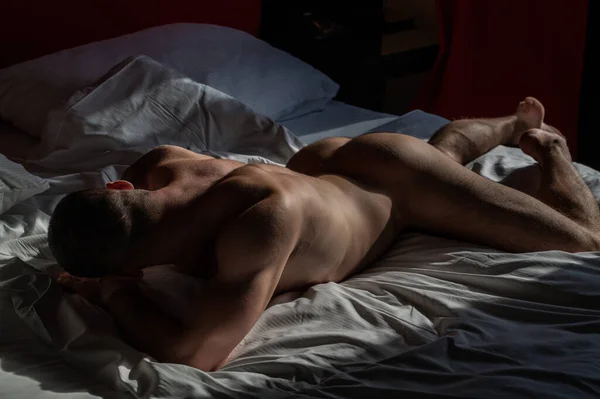 年轻性感的男人躺在床上英俊的年轻人赤身裸体赤身裸体衣衫褴褛肌肉发达的年轻人赤身裸体躺在床上 性感的年轻男模 — 图库照片