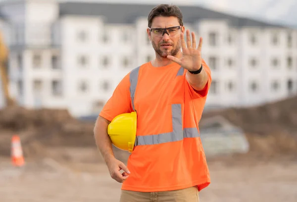 用手停止手势的工人 西班牙裔建筑工人戴头盔在大楼里 建筑大楼 建筑工地经理 新大楼里戴头盔的工人 — 图库照片