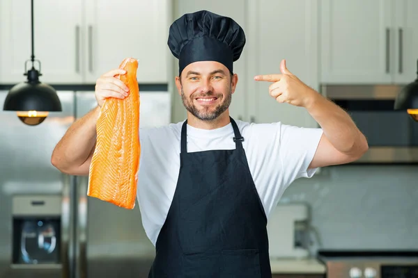 中年男子在厨房里煮鲑鱼 厨师在厨房里吃鲑鱼 天然蛋白质概念 健康食品概念 健康饮食 肉类蛋白质 — 图库照片