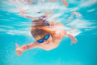 Havuzda yüzen bir çocuk. Komik küçük çocuk havuzda su altında yüzüyor. Suyun altındaki çocukların portresi. Yaz tatili. Çocuklar hafta sonu