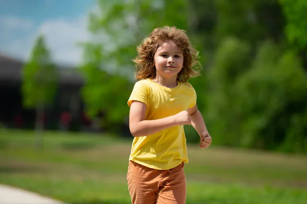 可爱的小男孩跑过美国附近的街道 闲暇和人的概念 快乐的金发碧眼的小男孩在室外的夏季公园里奔跑 体育与跑步 图库图片