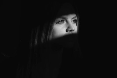 Stylish sexy woman on a gray background. Sensual young model on black studio. Fashion portrait of elegant woman in shadow