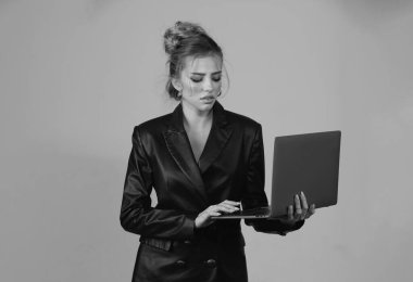 İzole edilmiş arka planda dizüstü bilgisayar kullanan seksi ciddi kadın.