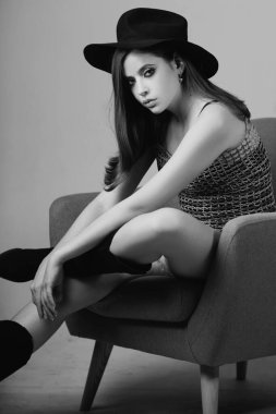 Şapkalı manken. Moda modeli. Stüdyoda şık bir kadın moda elbisesi giyiyor. Güzel kız moda kıyafetleri giyer. Günlük kıyafet, moda tarzı.