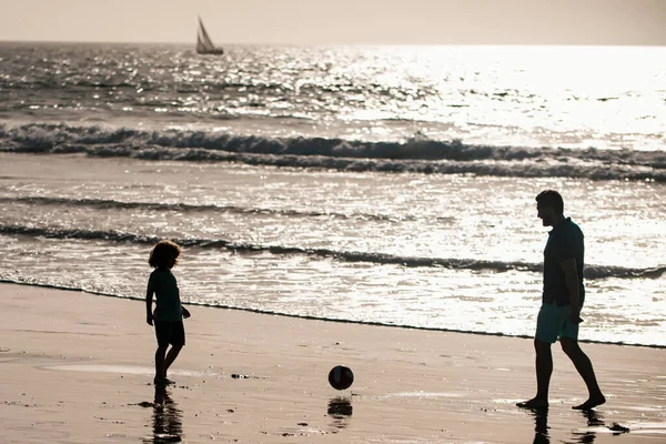 父と息子はビーチでサッカーやサッカーをします 家族旅行 父の日の概念 屋外で遊んでいる父と子供 — ストック写真