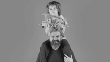 Oğlu babası ve büyükbabası ile oyuncak uçağı olan bir çocuk izole bir arka planda oynuyor. Aile macerası, yenilik ve ilham