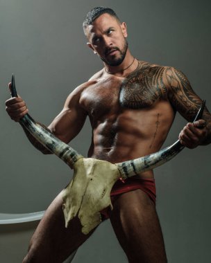 Boynuzlu kavramı. Gri arka planda yakışıklı vahşi bir adam.