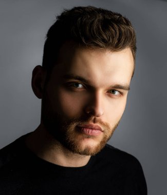 Gri arka planda izole edilmiş seksi bir adam.