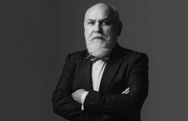 Kıdemli adam. Kendine güvenen işadamı kollarını kavuşturmuş poz veriyor.