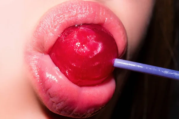 女性の口の中でロリポップ 赤い口紅 赤い光沢のあるロリポップを舐める女性 閉めろ セクシー女性とともにロリポップで官能的な口 — ストック写真