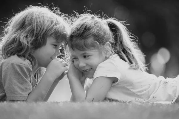 小さな男の子と女の子の親友抱擁 夏の公園で愛を持ってキスをする子供たち 友達だ 草の上に寝そべっている兄弟姉妹 — ストック写真