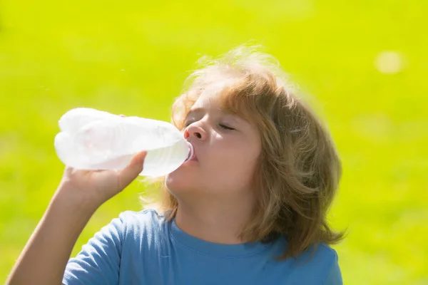 孩子喝水 带着一瓶淡水的小孩的画像 口渴的孩子重温 水平衡 近照小孩在公园喝水的肖像 儿童饮水的肖像 — 图库照片