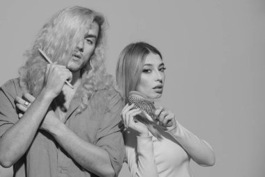 Uzun parlak ipek saçlı güzel bir çift ve taraklı sarı kıvırcık saçlı bir adam. Kıvırcık saçlı adam, düz saçlı kadın.