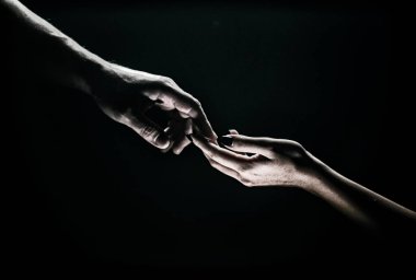 Two hands reaching toward. Tenderness, tendet touch hands in black background. Romantic touch with fingers, love. Hand creation of adam