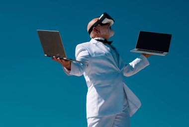 Sanal gerçeklik ve gelecekteki teknoloji kavramına sahip kıdemli yaşlı adam. VR 'daki eski iş adamı. 3D gözlüklü ve dizüstü bilgisayarlı adam.