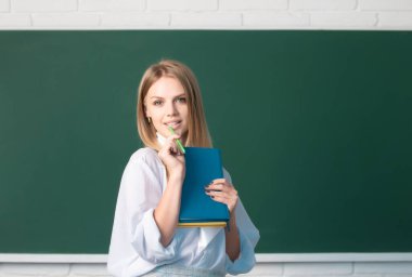 Üniversitede ya da okulda bayan üniversite öğrencisinin portresi. Üniversitede bir kitaptan notlar alan kız öğrenci.