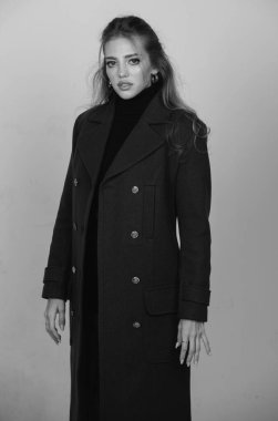 Vogue female coat. Young glamour woman wearing stylish fashion dress. Fashion model in studio