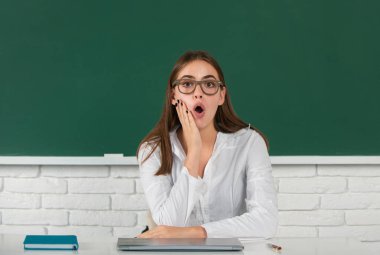 Sınıfta karatahta geçmişi olan genç bir kız öğrencinin portresi. İnanılmaz liseli kız.