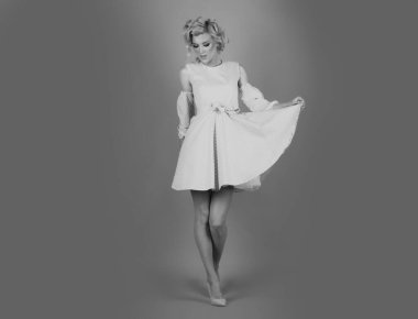 Güzel, genç, bebek yüzlü, moda makyajlı, pembe elbiseli, pembe arka planda poz veren kadın modeli. Güzel lüks sarışın. Moda modası geçmiş giyim mağazası.