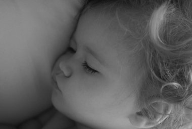 Yatakta uyuyan bebeğin yakın çekim yüzü. Uykulu çocuk portresi