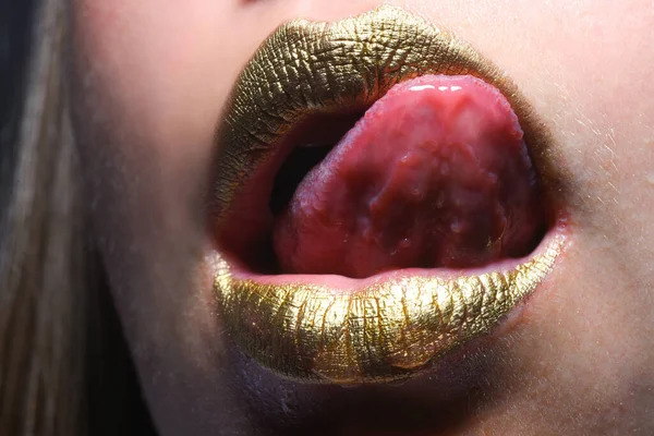 官能的な舌舐め唇 口に金泥を塗る 黄金の唇 豪華な金の唇のメイクアップ 創造的な金属口紅と黄金の唇 金の金属の唇 官能的な女性の口を閉じてマクロ — ストック写真