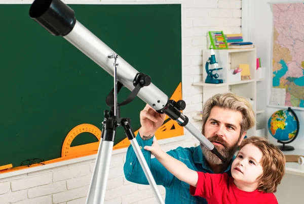 教師と一緒に星を見ている人形 天文学望遠鏡 幸せなかわいい勤勉な子供は屋内の机に座っています 個別指導 — ストック写真