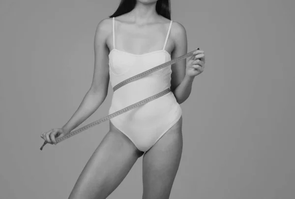 テープで女性の腰 女性モデルボディケア 女性は手でメートルを保持し 腰を測定します ボディケア — ストック写真