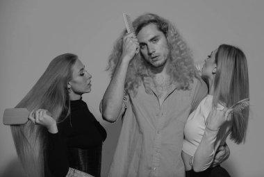 Grup kadınları ve erkekler sağlıklı saç bakımlarını, saç modellerini tarıyor. Saç tarayan bir grup genç. Arkadaşlar tarakla uzun, pürüzsüz saçlarını tarıyorlar. Saç bakım konsepti