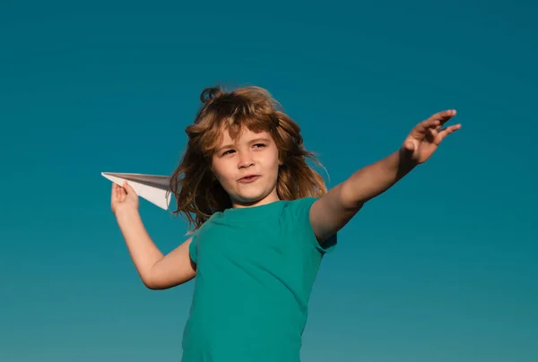 青い空の背景を持つ紙飛行機を投げる子供の男の子 — ストック写真
