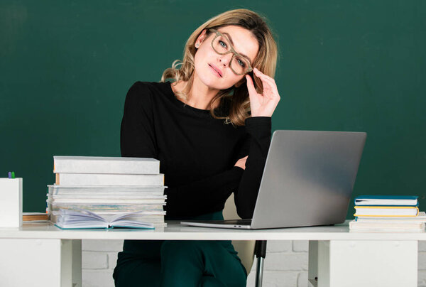 Teacher in classroom at university or college. Female beautiful student on board with computer laptop. Lesson seminar skills. Young woman study in high school